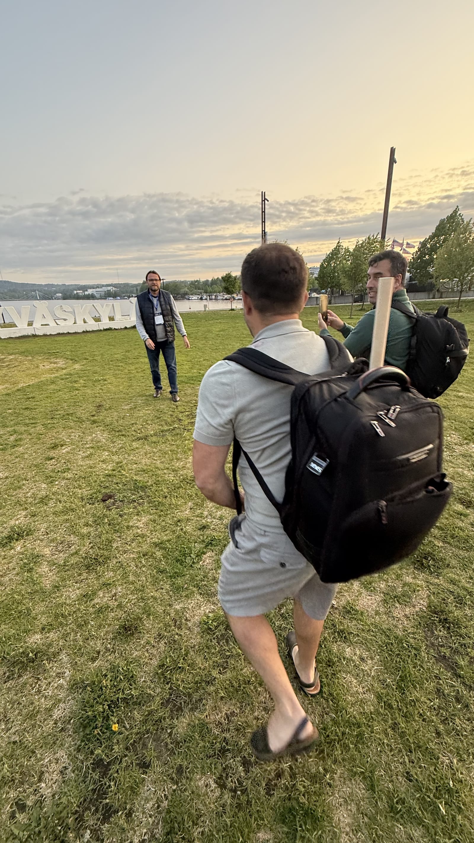 Partida de mölkky entre asistentes del World Sauna Forum 2025 junto al cartel de Jyväskylä al atardecer